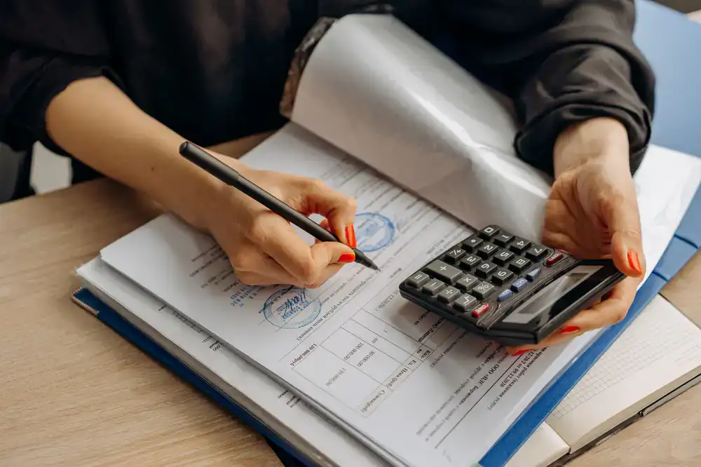 Close up of a professional sorting receipts and maintaining business ledgers